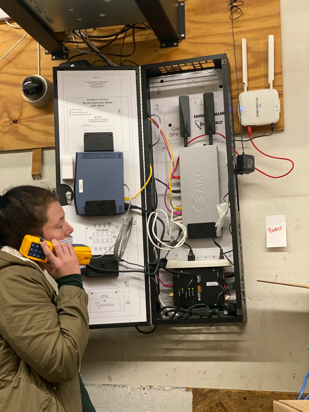 Technician testing network equipment in a cabinet.